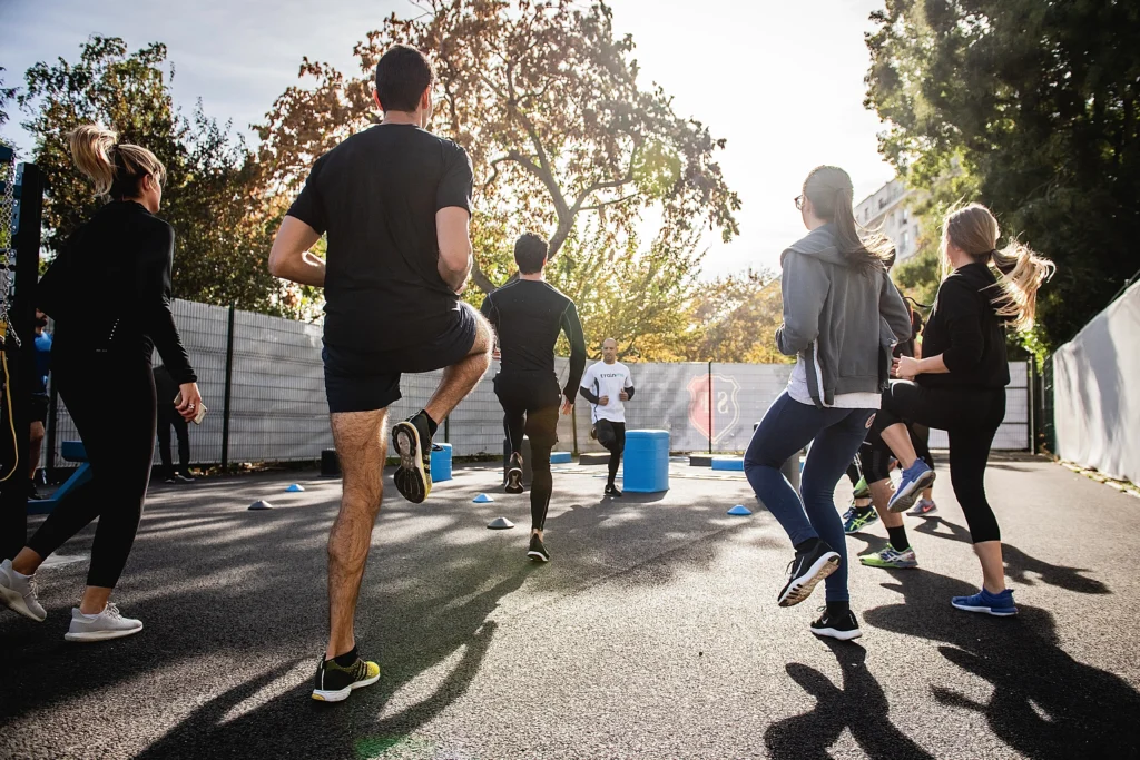 Group doing HIIT exercises with coach at the center