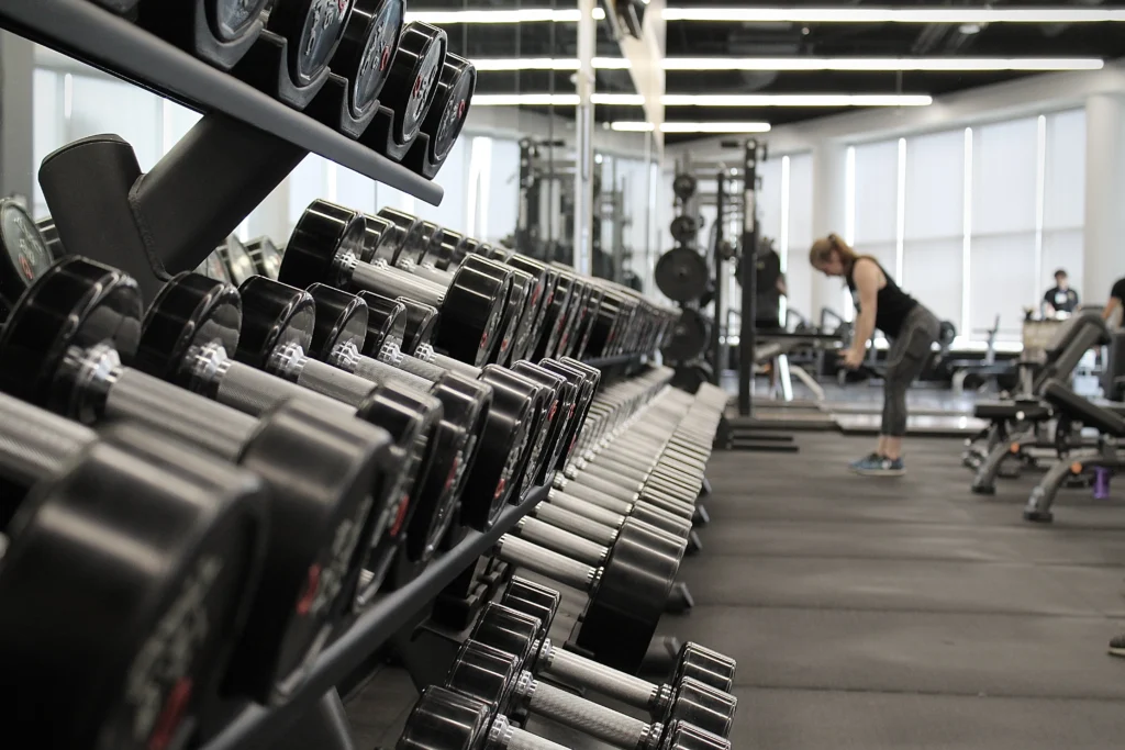 A girl doing exercise with dumbbells in gym