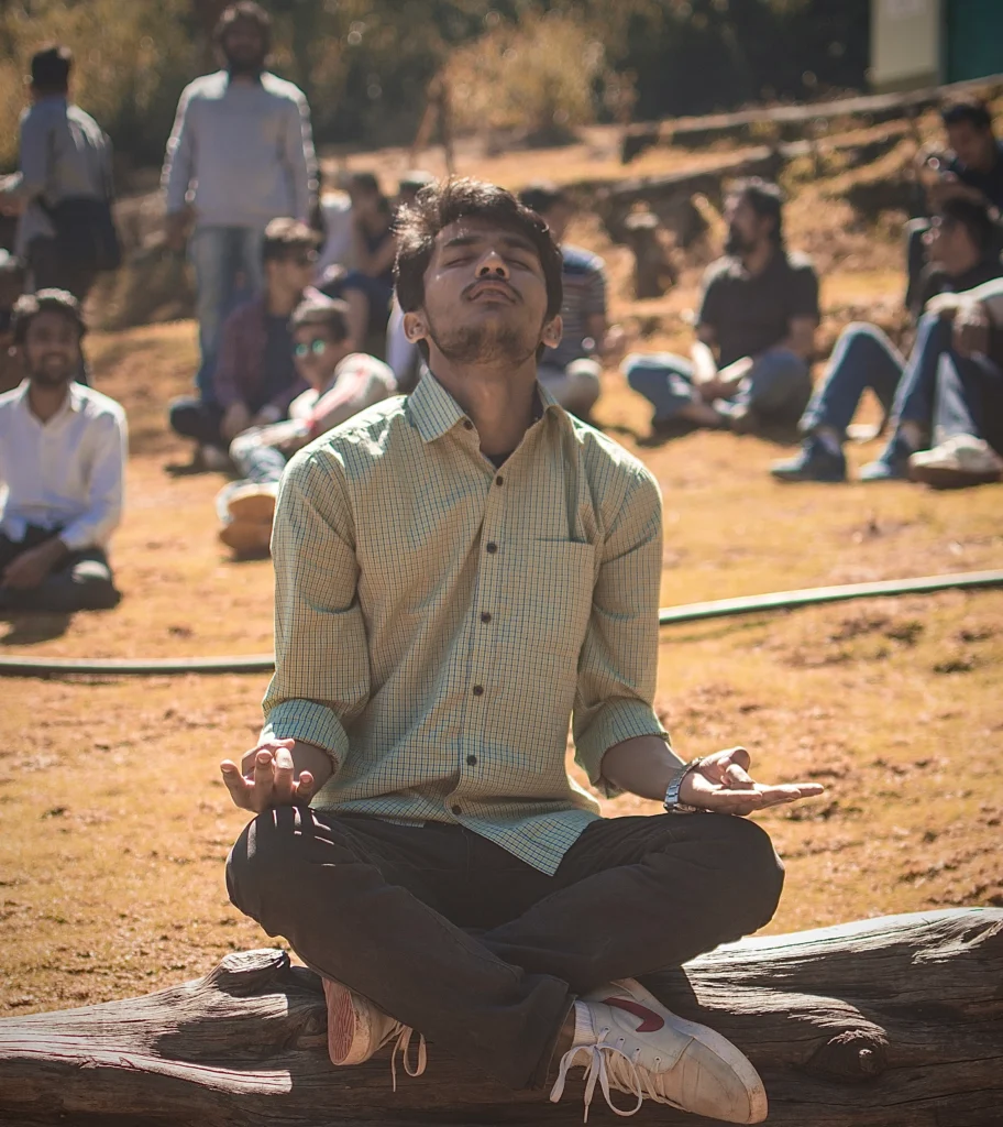 A boy meditating on a peaceful ground surrounded by friends, illustrating the concept of 'Surround Yourself with Positivity'