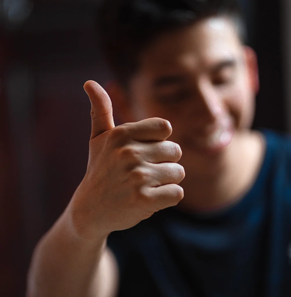 Image of a man giving a thumbs-up gesture, symbolizing 'Motivation and Persistence' in achieving goals