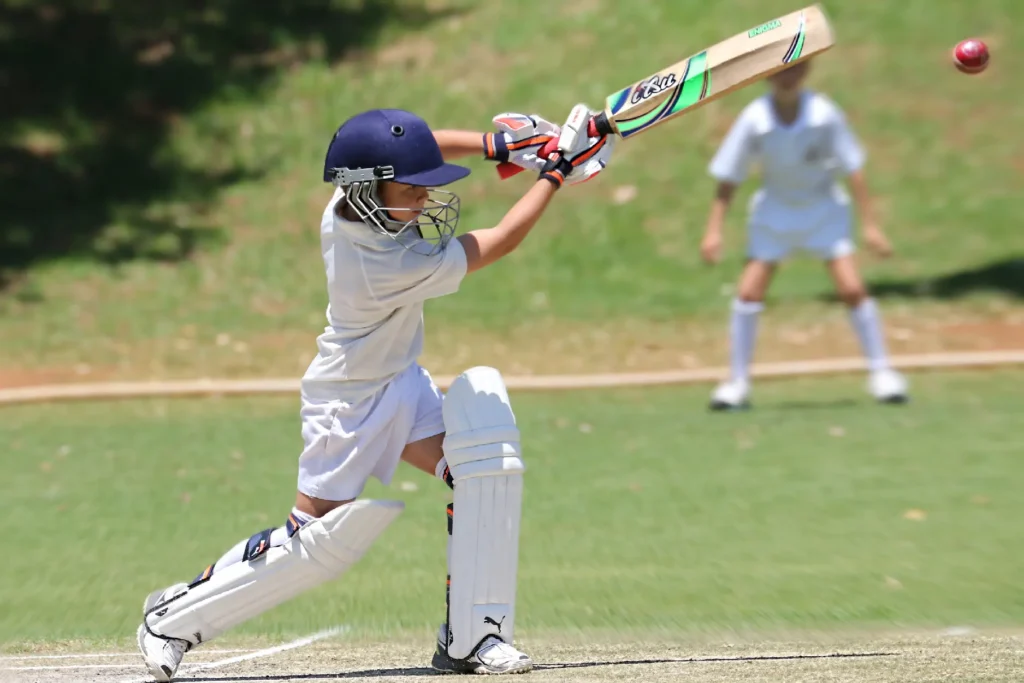 Elementary school students playing cricket